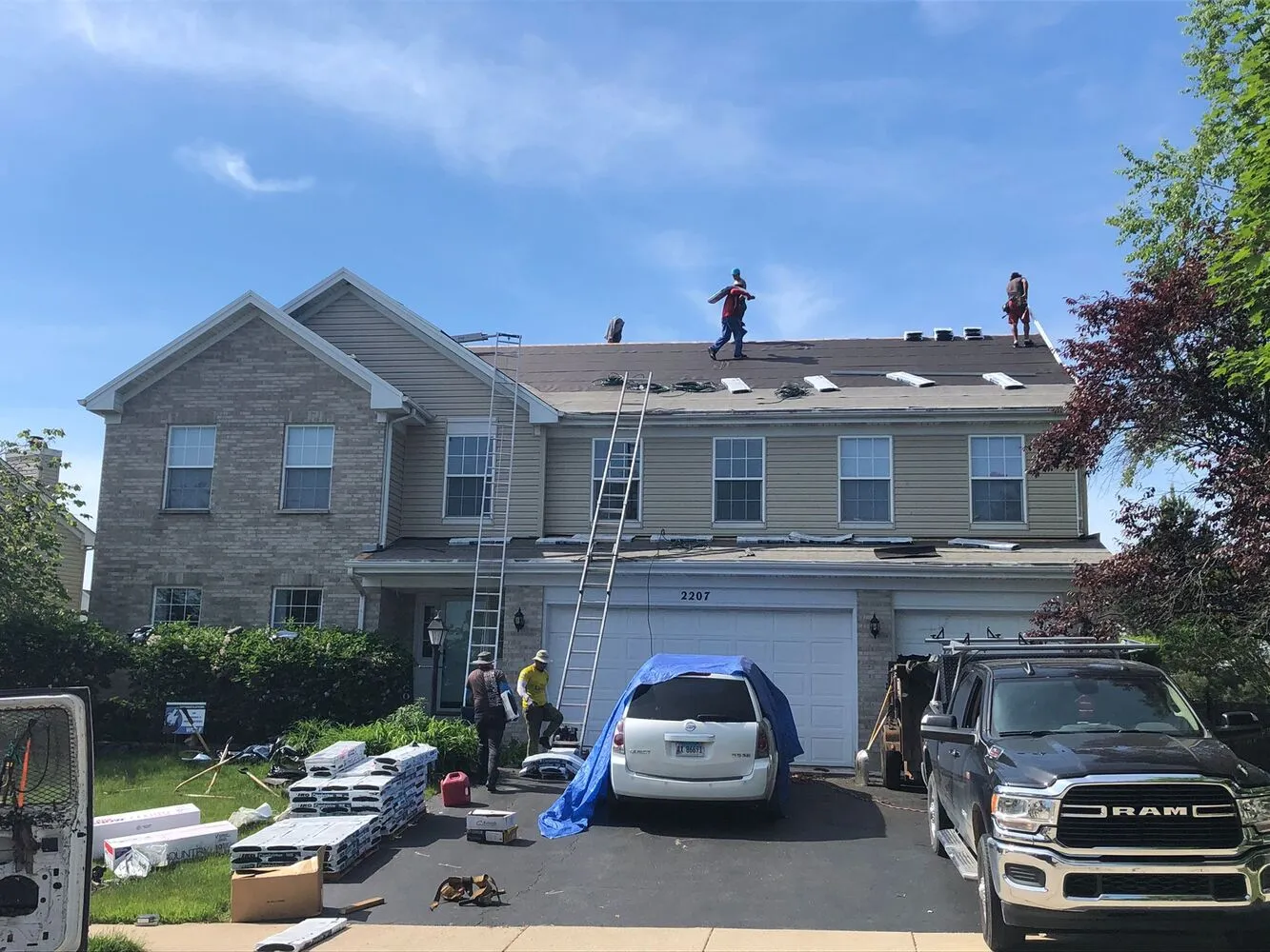 full house exterior with roofing contractor team working on the roof
