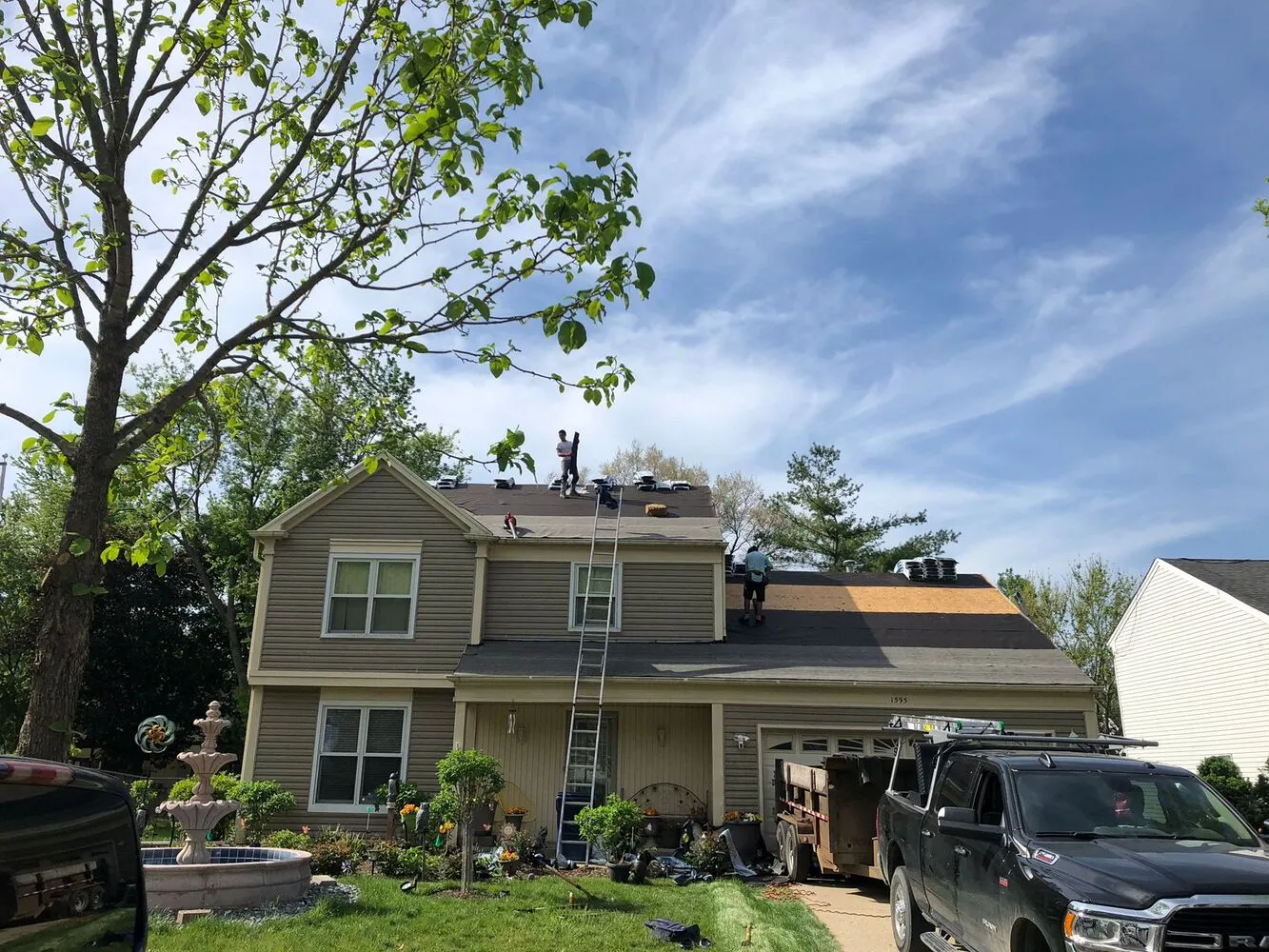 full house exterior with roofing contractor team working on the shingle roof